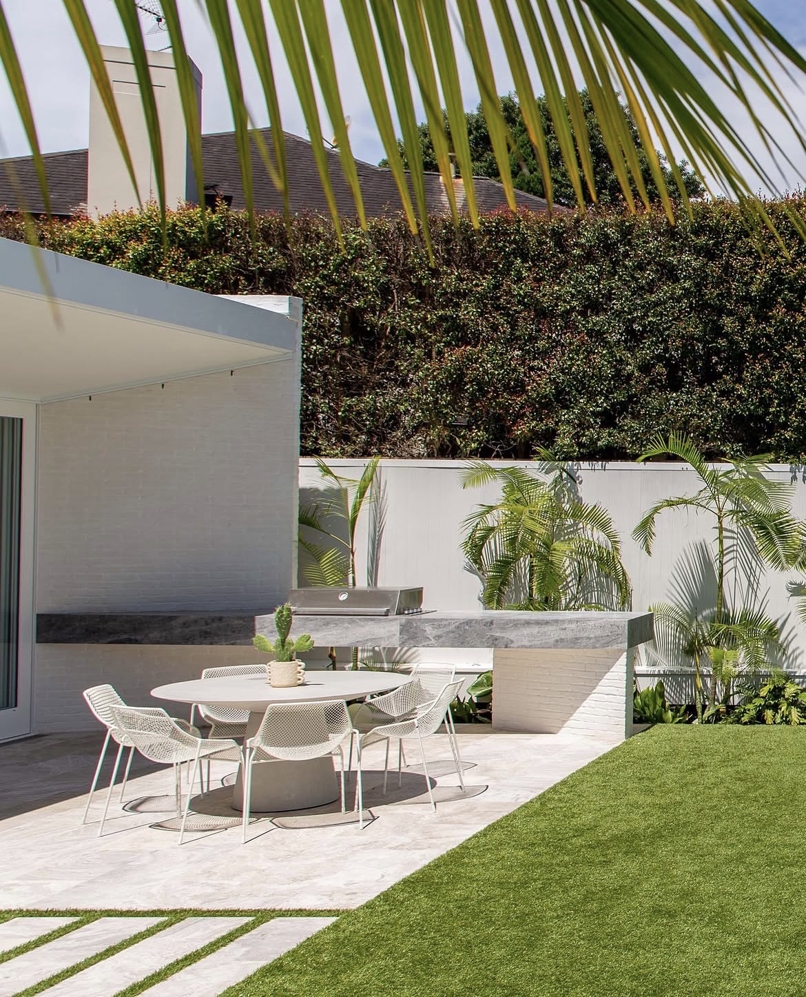 Outdoor entertaining area with manicured lawn and coastal planting in a Sydney backyard