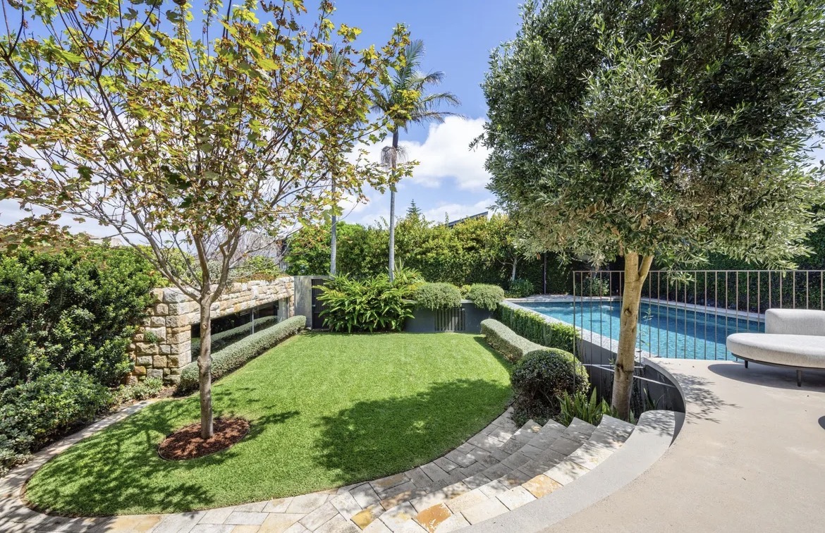 Manicured curved lawn with sandstone edging and established trees in a Sydney garden